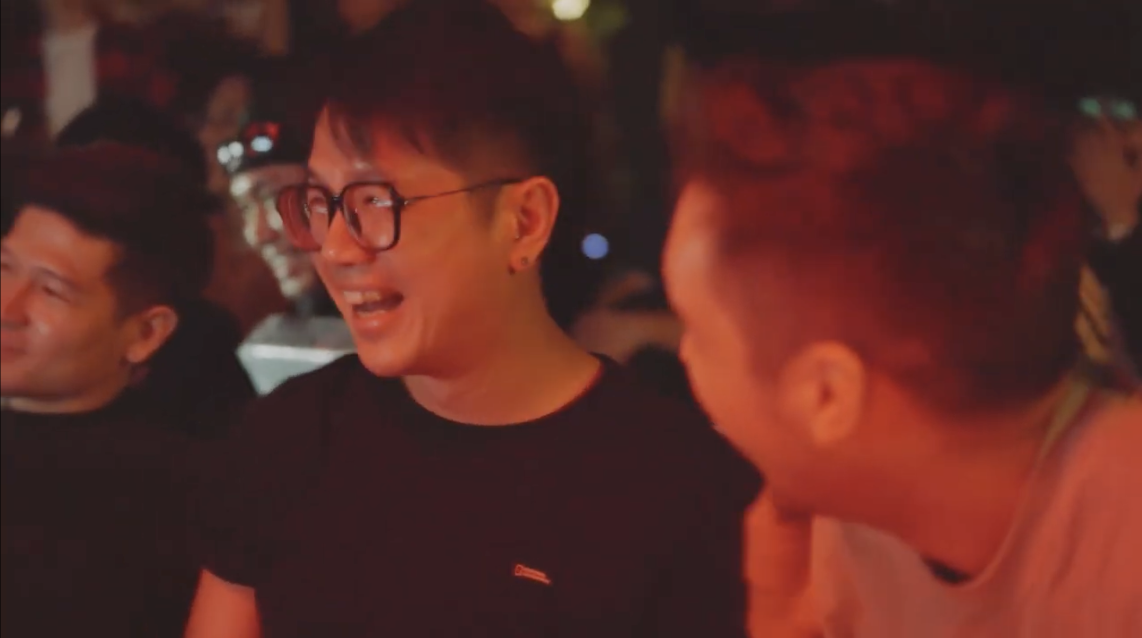 Guests laughing together under red light