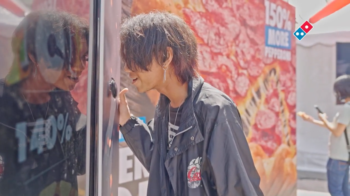 Passer-by peering into the Domino's 150% More Pepperoni activation booth