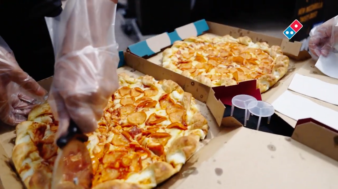 Crew slicing fresh pizzas for the crowd