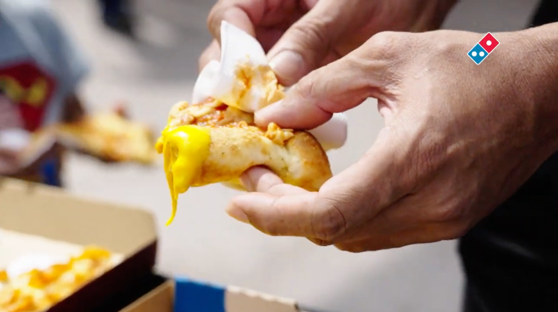 Close-up of a cheesy crust being pulled apart