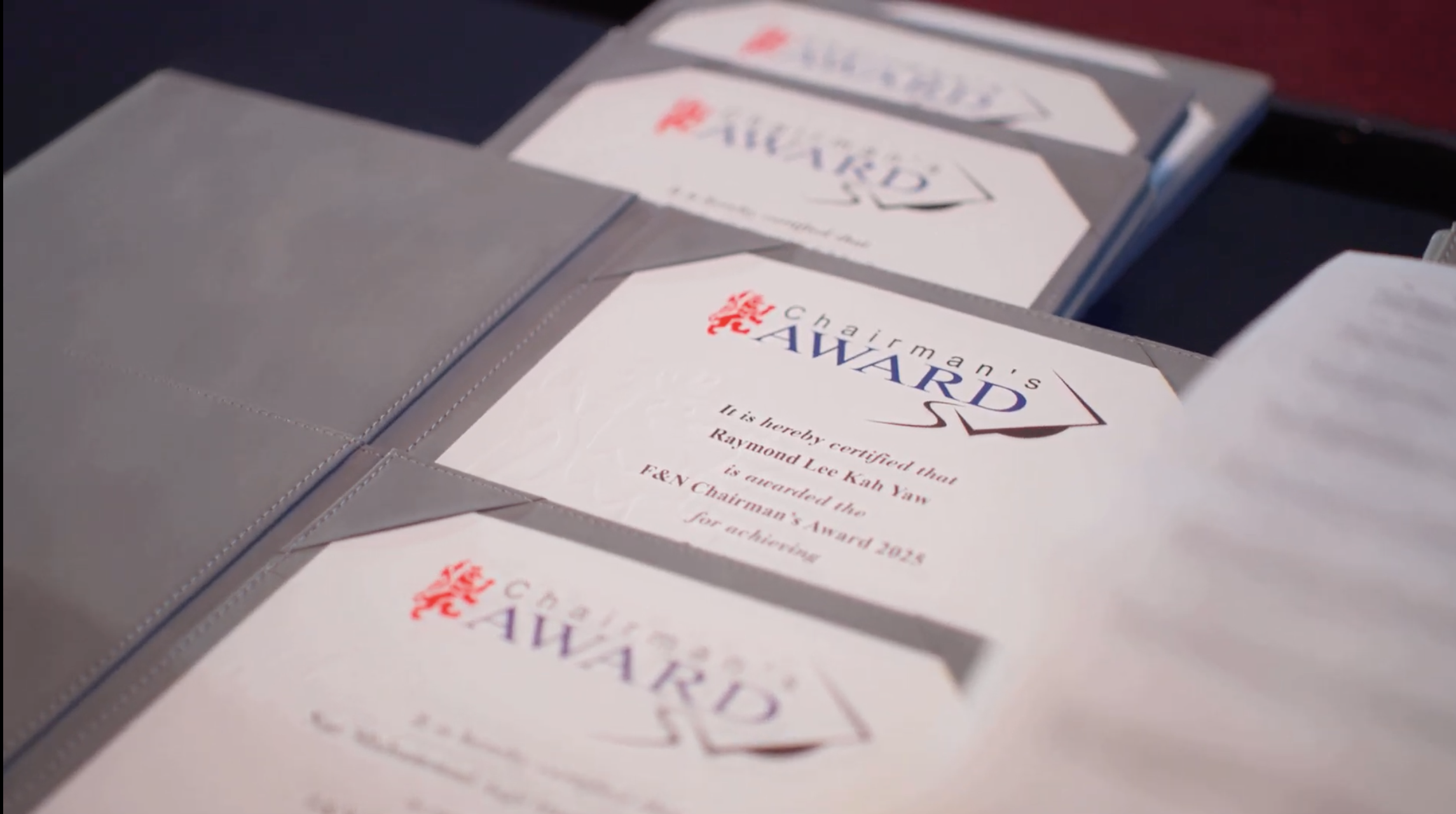 Close-up of Chairman's Award certificates in folders