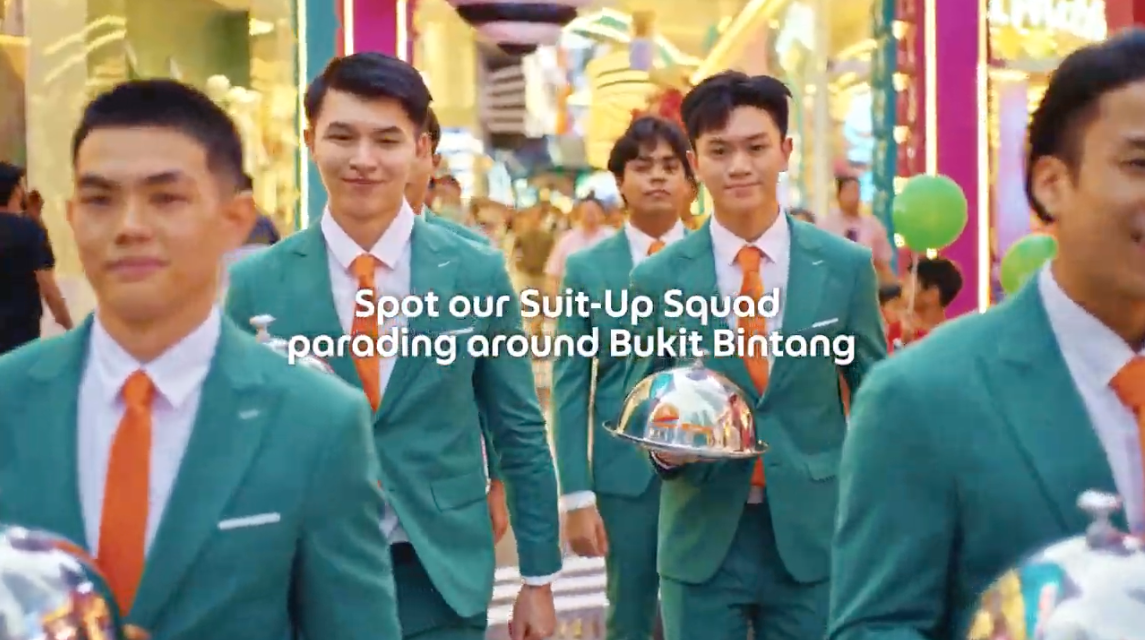 Suit-Up Squad in green suits carrying silver cloches