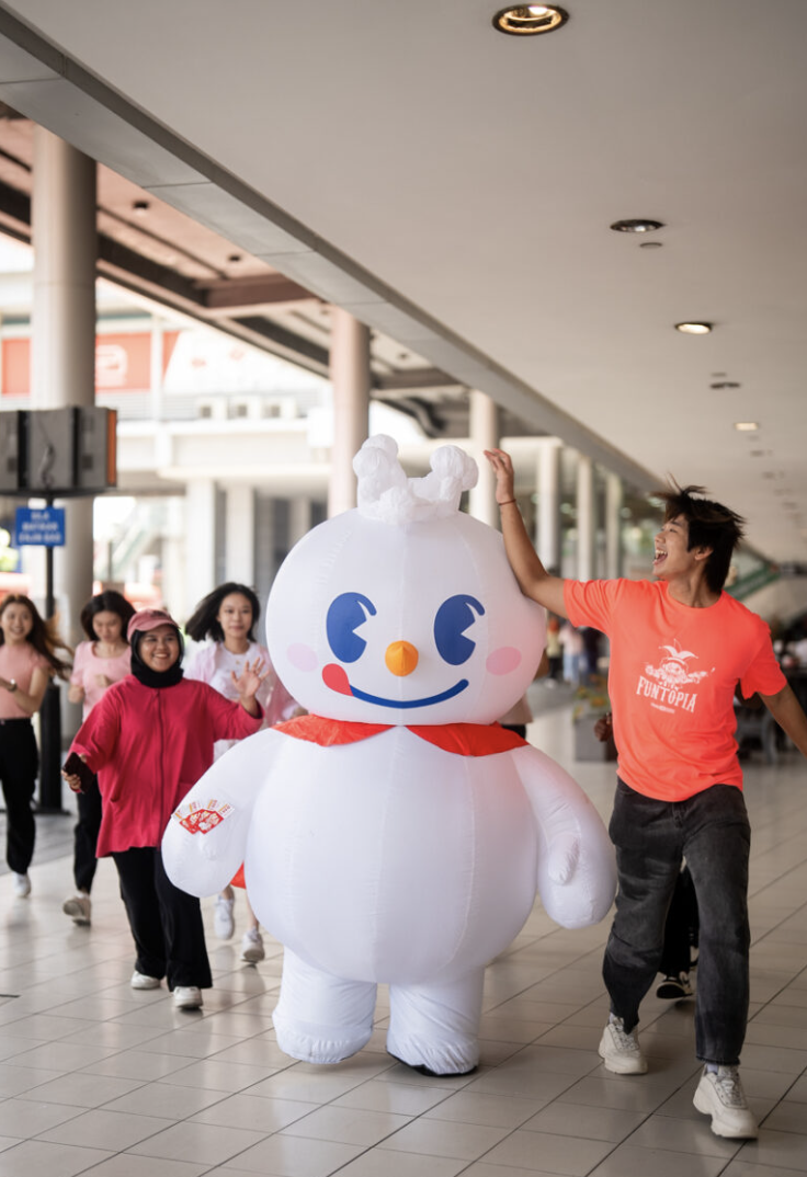 Snow King mascot walking with fans in a mall