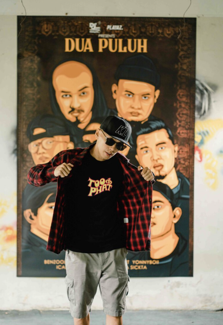 Model in Too Phat tee and flannel in front of a poster